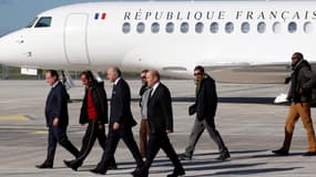 François Hollande, Laurent Fabius, Jean-Yves Le Drian et les quatre ex-otages au Sahel, sur le tarmac de Villacoublay, mercredi 30 octobre.