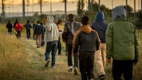 Des migrants marchent en direction du site Eurotunnel près de Calais