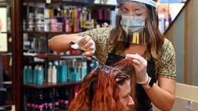 Dans un salon de coiffure à Birkenhead, dans le nord-ouest de l'Angleterre, le 4 juillet 2020, date de la réouverture des coiffeurs, pubs, restaurants et bed & breafast dans le pays, étape clé du déconfinement