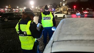 Des policiers contrôlent les passagers d'un véhicule place de la Concorde à Paris, le 16 janvier 2021, lors de l'entrée du couvre-feu avancé à 18 heures.