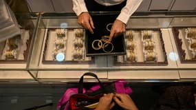 Un gérant de magasin en train de parler avec des clients dans une bijouterie, le 11 août 2021