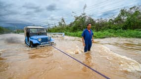 Un conducteur tente de sortir son véhicule d'une zone inondée après les fortes pluies provoquées par l'ouragan Melissa dans la ville de San Miguel de Parada, province de Santiago de Cuba, le 29 octobre 2025.