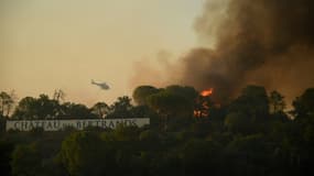 Un hélicoptère bombardier d'eau survole l'incendie autour de Gonfaron (Var), le 17 août 2021