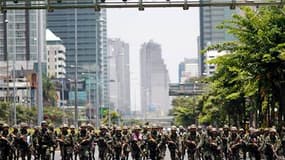 Soldats thaïlandais marchant en direction du campement des "chemises rouges" dans le centre de Bangkok. La situation est explosive dans le centre de Bangkok après une nuit d'affrontements entre soldats et manifestants antigouvernementaux qui ont fait un m