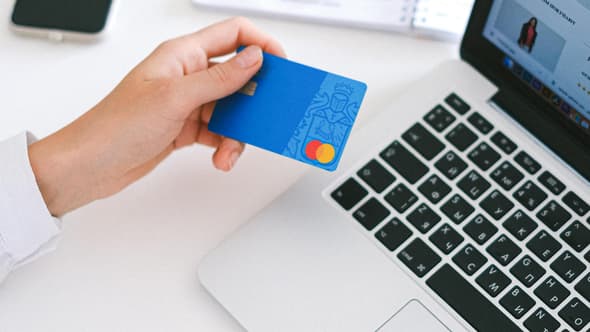 Une femme règle des achats en ligne avec une carte bancaire (photo d'illustration).