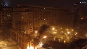 Sur la place Tahrir, au Caire, des policiers anti-émeutes mettent le feu aux tentes de manifestants contestant le président égyptien Mohamed Morsi. Des centaines de manifestants, jeunes pour la plupart, ont affronté la police dans la nuit de jeudi à vendr