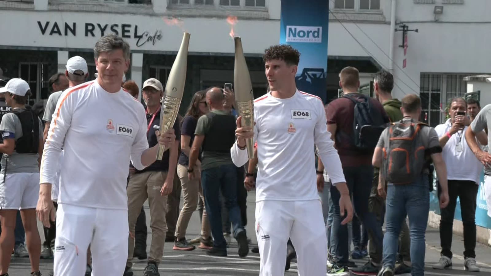 Pierre-Ambroise Bosse et Philippe Oddou se transmettent la flamme olympique devant le vélodrome de Roubaix