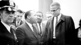 Les militants des droits civiques Martin Luther King (à gauche) et Malcolm X, le 26 mars 1964 attendant une conférence de presse dans un lieu non-connu. (Photo d'archive)