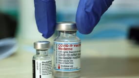 Un médecin dépose sur une table deux flacons des vaccins contre le coronavirus de Moderna et de Pfizer, avant d'en administrer des doses, le 10 août 2021 à Jérusalem (photo d'illustration)