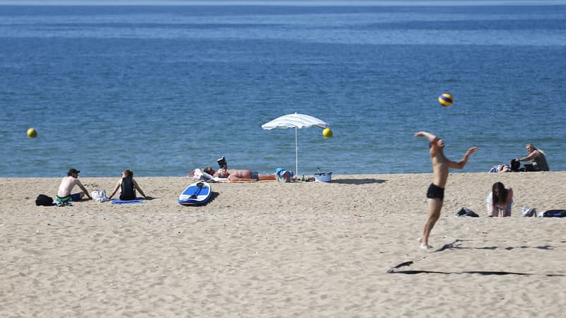 Des personnes bronzent au soleil sur une plage de Ouistreham, dans le nord-ouest de la France, le 5 juillet 2018. 