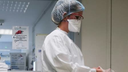 Une interne enfile des gants de protection dans le service de médecine interne de l'hôpital Emile Muller de Mulhouse, le 16 février 2021
