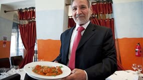 Ahmed Aslam Ali, le propriétaire du restaurant Shish Mahal à Glasgow, avec une assiette de poulet tikka masala, le 29 juillet 2009.