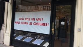 La pancarte parodique, dans la vitrine d'un magasin de costumes, à Paris.