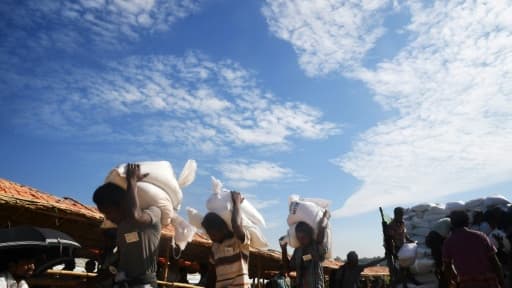 Des réfugiés rohingyas portent des sacs d'aide humanitaire, au camp de Thankhali, au Bangladesh, le 12 novembre 2017