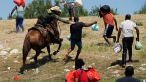 Un garde-frontières américain à cheval tente de stopper un migrant haïtien d'entrer dans un campement sur les rives du Rio Grande, à Del Rio, au Texas, le 19 septembre 2021