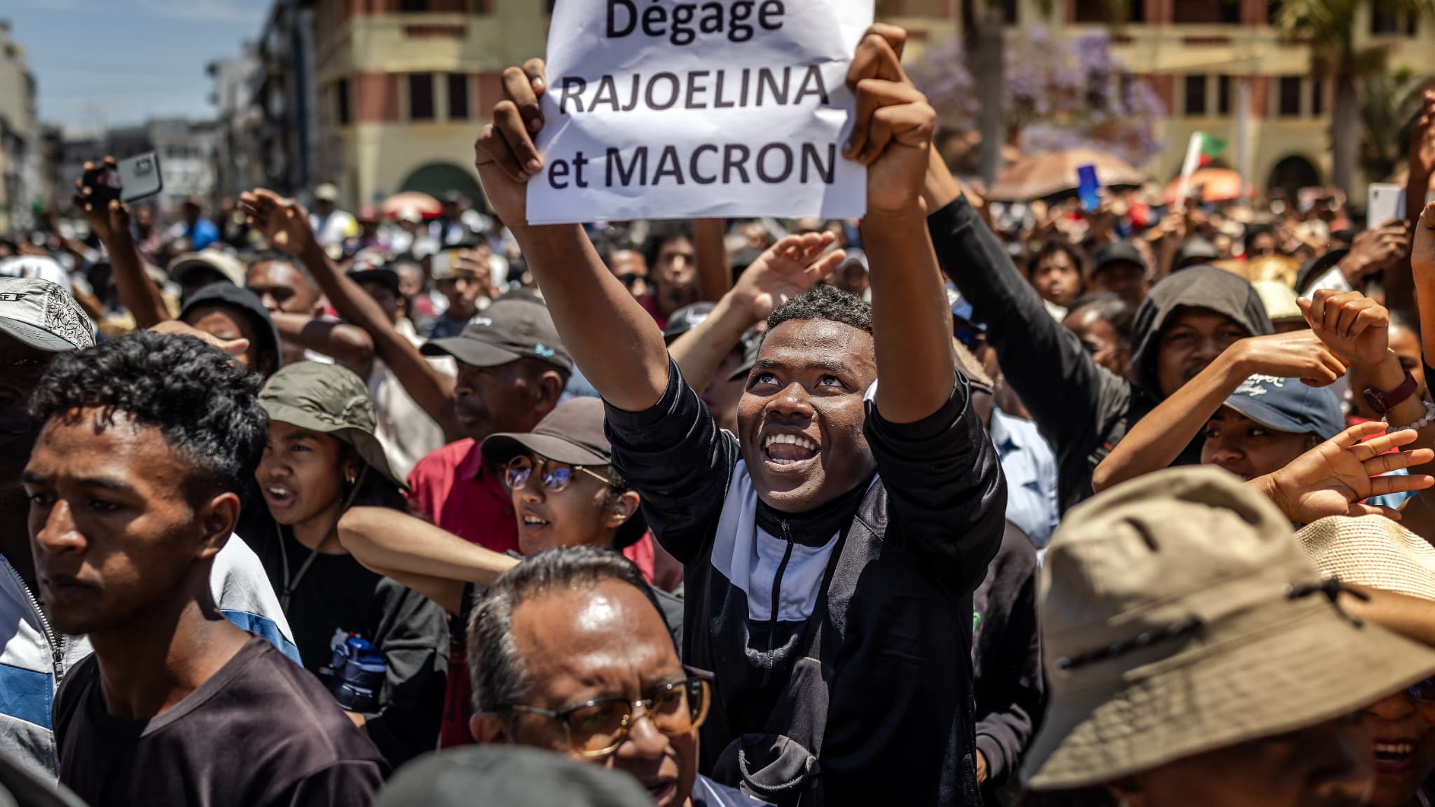 Un manifestant brandit une banderole critiquant le président malgache Andry Rajoelina et le président français Emmanuel Macron, à Antananarivo, le 14 octobre 2025. Un manifestant brandit une banderole critiquant le président malgache Andry Rajoelina et le président français Emmanuel Macron, à Antananarivo, le 14 octobre 2025.