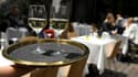Un serveur porte un plateau avec des verres de vin sur la terrasse d'un restaurant à Marseille, le 19 mai 2021.