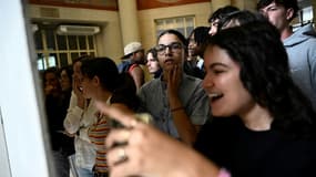 Des lycéens consultent les résultats du baccalauréat dans le hall du lycée Claude-Bernard, le 8 juillet 2024 à Paris