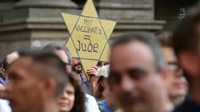 Un manifestant brandit une étoile jaune sur laquelle est inscrit "Pas vacciné = Juif", lors d'une manifestation contre le pass sanitaire à Milan, le 24 juillet 2021