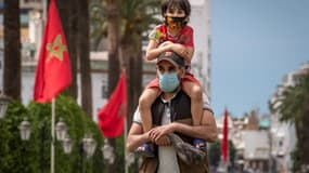 Un père et son fils portent un masque de protection contre le coronavirus, le 16 juin 2020 à Rabat, au Maroc