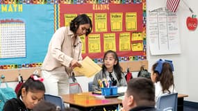 Une enseignante travaille avec des élèves de l'école primaire Nevitt à Phoenix, en Arizona. L'Arizona, comme la plupart des États, impose une année scolaire de 180 jours pour les écoles publiques de la maternelle à la terminale (image d'illustration)