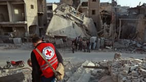 Un bénévole de la Croix rouge internationale parcourt des ruines à Douma, dans la Ghouta orientale le 5 mars 2018. 