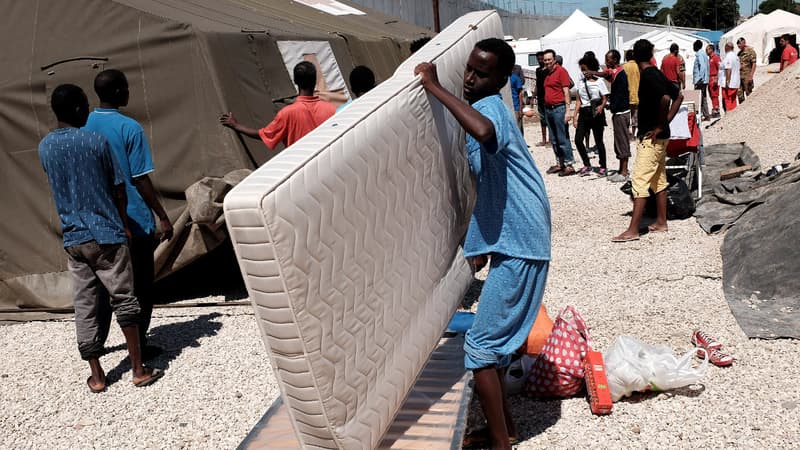 Un migrant transporte un matelas à son arrivée en gare de Tiburtina à Rome, le 20 août 2015