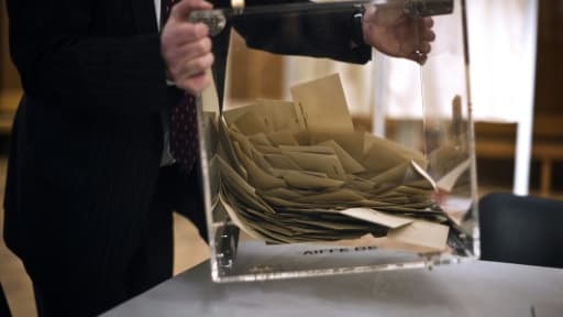 Un scrutateur vide l'urne contenant les bulletins de vote, le 20 mars 2011 à Dijon