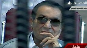 L'ex président égyptien Hosni Moubarak dans le box à l'ouverture de son procès, le 11 mai.