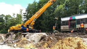 Deux grues ont été nécessaires pour relever le train couché sur la voie.