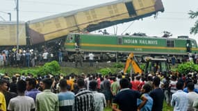 Des personnes se rassemblent près du site d'une collision entre un train de passagers et un train de marchandises à Nirmaljote, près de la gare de Rangapani, dans l'État indien du Bengale occidental, le 17 juin 2024.