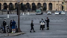 Des forces de l'ordre en train de contrôler un individu en scooter à Paris au premier jour du confinement au moins de mars 2020.