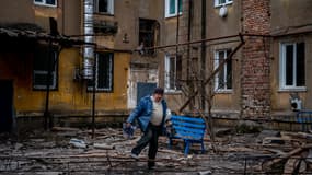 Un homme transporte ses affaires en quittant un immeuble endommagé à Chasov Yar, en Ukraine, le 5 janvier 2023