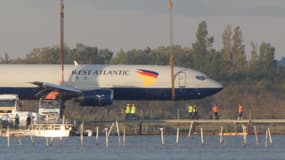 L'avion de fret a été transporté à l'aide de deux grues qui ont dû se coordonner pour éviter toute pollution, particulièrement les écoulements d'hydrocarbures.