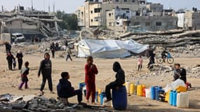 Des enfants palestiniens font la queue pour se réapprovisionner en eau dans un camp de déplacés improvisé dans la ville de Gaza, le 11 janvier 2025.