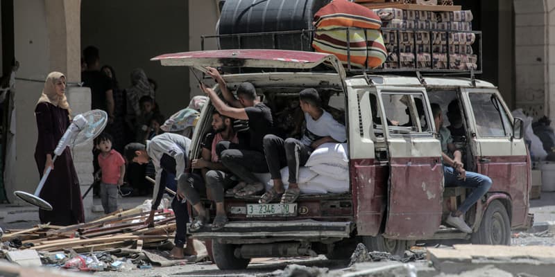 Des Palestiniens qui ont fui Rafah, dans le sud de la bande de Gaza, déchargent leurs affaires de l'arrière d'un camion à leur arrivée pour se réfugier à Khan Yunis le 12 mai 2024, au milieu du conflit en cours entre Israël et le groupe militant du Hamas.