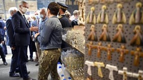 Bruno Le Maire dans une boutique de souvenirs près du sanctuaire de Notre-Dame de Lourdes, le 10 août 2020, lors de sa visite pour soutenir les professionnels du secteur du tourisme