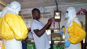 A Conakry en Guinée, pays voisin de la Sierra Leone, des membres de Médecins Sans Frontières se parent de protections, le 23 juillet 2014.
