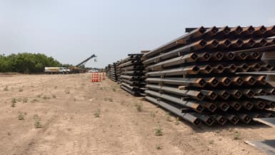 Des poteaux en acier inutilisés reposent près d'une partie du mur frontalier inachevé à la frontière entre les États-Unis et le Mexique, le 14 avril 2021 à La Joya (Texas).