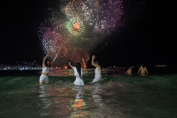 Des personnes célèbrent le traditionnel feu d'artifice du Nouvel An sur la plage de Copacabana à Rio de Janeiro, au Brésil, le 1er janvier 2024.