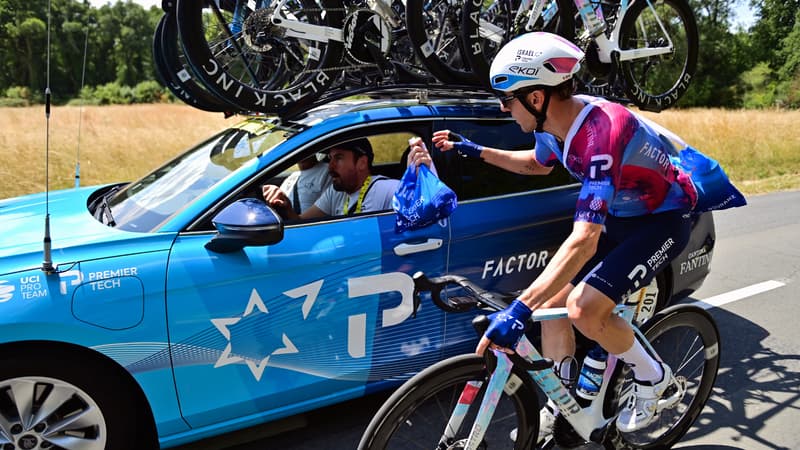 Michael Woods se ravitaille auprès de sa voiture lors de la 9e étape du Tour de France, le 13 juillet 2025