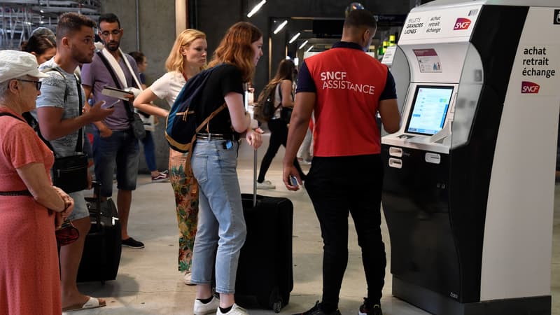Un agent de la SNCF aide des voyageurs dans la gare Montparnasse, le 28 juillet 2018, alors que la circulation est fortement perturbée par une panne électrique.