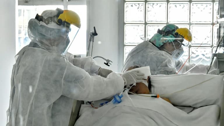 Deux infirmiers s'affairent autour d'un malade atteint du Covid-19 - Image d'illustration