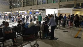 Des passagers attendent devant l'aéroport Napoléon Bonaparte d'Ajaccio, en Corse, le 3 octobre 2024