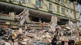 Les secours recherchent parmi les débris de l'effondrement d'un immeuble d'éventuels survivants, alors que près de 90 personnes pourraient y être piégées. 