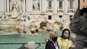 Des touristes portant un masque devant la fontaine de Trevi à Rome, le 25 septembre 2020.