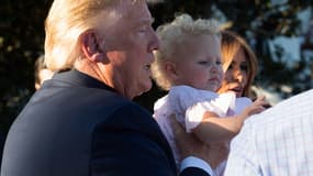 Donald Trump portant un bébé lors d'un pique-nique à la Maison-Blanche en juin 2019.