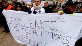 Un homme lors d'une marche blanche en hommage à Tony, ce petit garçon de 3 ans mort sous les coups de son beau-père en 2016 à Reims.