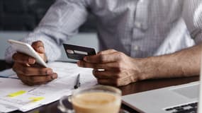Un homme effectuant un virement bancaire depuis son téléphone (photo d'illustration).