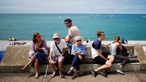 Des touristes assis près de la plage d'Etretat, dans le Nord-Ouest de la France. (Photo d'illustration)